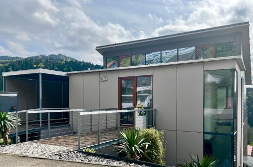 a modern house with glass doors andwindows at WEITBLICK "entspannen - wohlfühlen - aktiv erholen" in Elzach