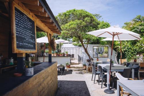 a restaurant with tables and chairs and an umbrella at The Georgian House in Alderney