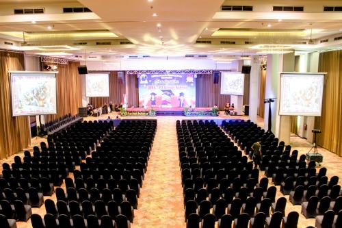 a large room with black chairs and a stage at Savana Hotel & Convention Malang in Malang