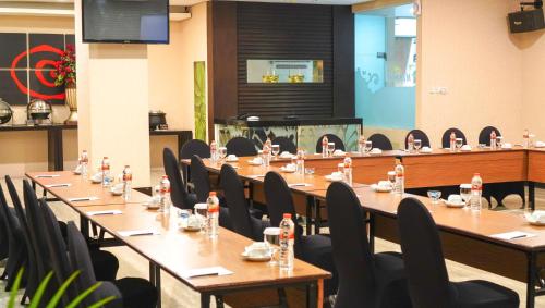 a meeting room with long tables and chairs at Savana Hotel & Convention Malang in Malang