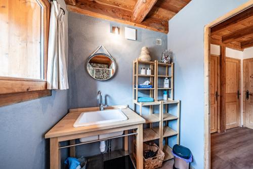 La salle de bains est pourvue d'un lavabo et d'un plafond en bois. dans l'établissement La Gravière, à La Salle Les Alpes