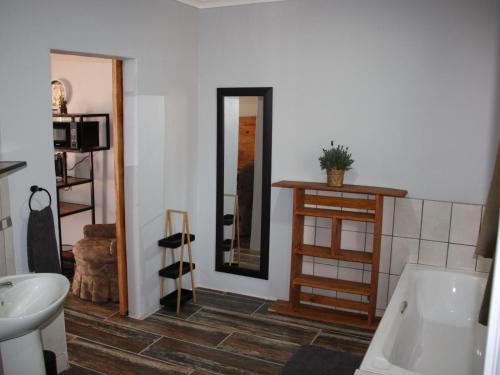 bagno con vasca, lavandino e specchio di Blesbok Inn a Polokwane