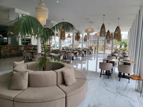 un restaurante con sofá, mesas y sillas en Edificio "Bahia" Punta Ballena. en Punta del Este