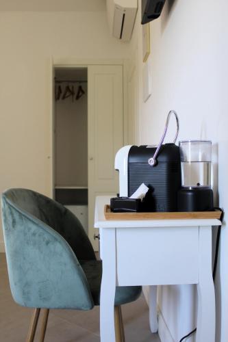a desk with a chair next to a table with a suitcase at Villa Forte Salvi - Rooms in Peschiera del Garda