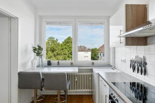 uma cozinha branca com uma janela e um balcão em E&K Apartment Kahrstraße em Essen