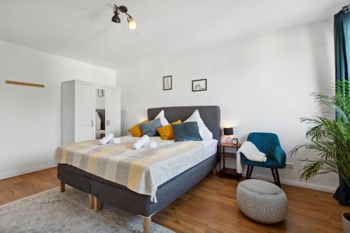 um quarto com uma cama e uma cadeira azul em E&K Apartment Kahrstraße em Essen