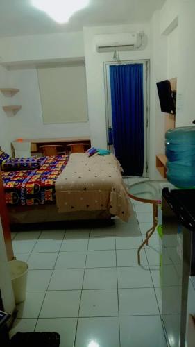 ein Schlafzimmer mit einem Bett und einem blauen Vorhang in der Unterkunft Sewa apartemen/transit gunung putri square Bogor in Parungtandjung