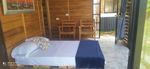 ピエデクエスタにあるCabañas de la lomaのベッドルーム1室(ベッド1台、ポーチチェア付)
