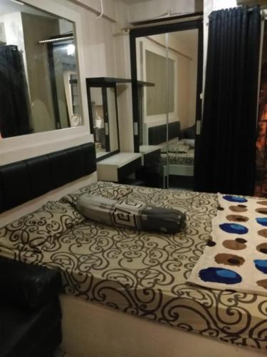 Zimmer mit einem Bett, einem Tisch und einem Spiegel in der Unterkunft Sewa apartemen/transit gunung putri square Bogor in Parungtandjung