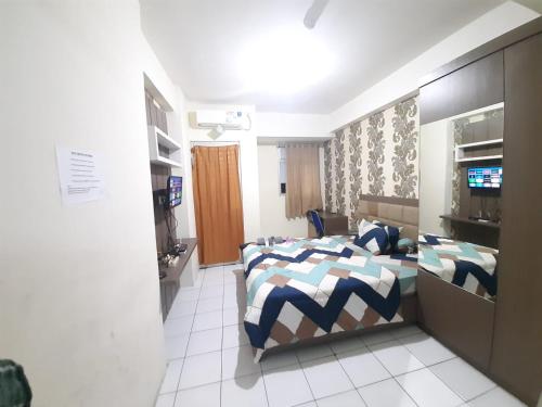 ein Schlafzimmer mit einem Bett und einem TV in der Unterkunft Sewa apartemen/transit gunung putri square Bogor in Parungtandjung
