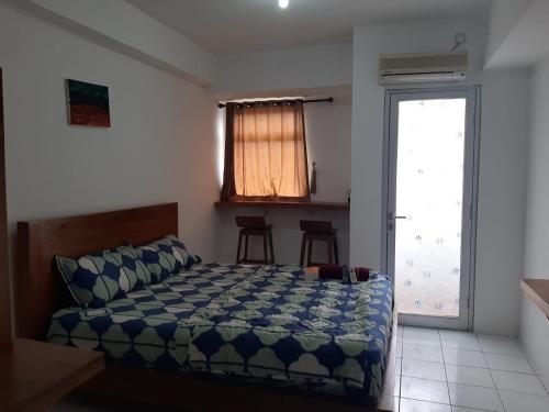 Schlafzimmer mit einem Bett und einer Glasschiebetür in der Unterkunft Sewa apartemen/transit gunung putri square Bogor in Parungtandjung