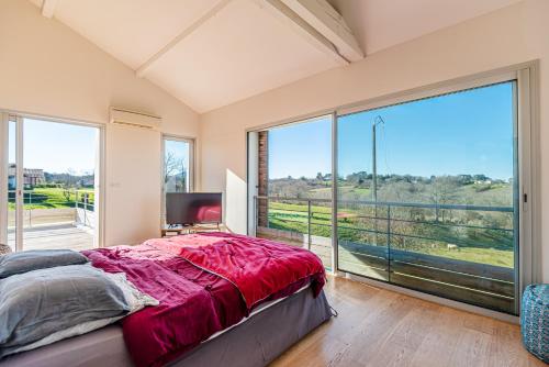ein Schlafzimmer mit einem Bett und einem großen Fenster in der Unterkunft VILLA ARCANGUES in Arcangues
