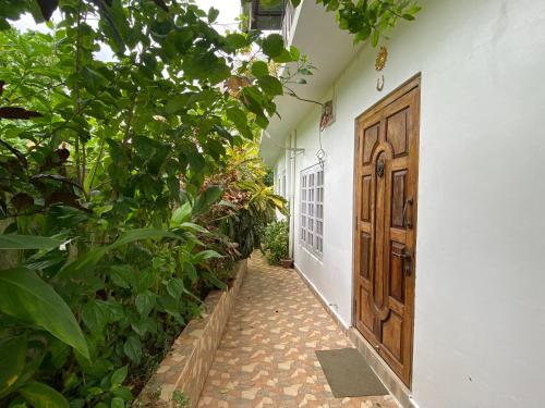 un pasillo con una puerta de madera y algunas plantas en Hibiscus Home Stay & Boutique, en Port Blair