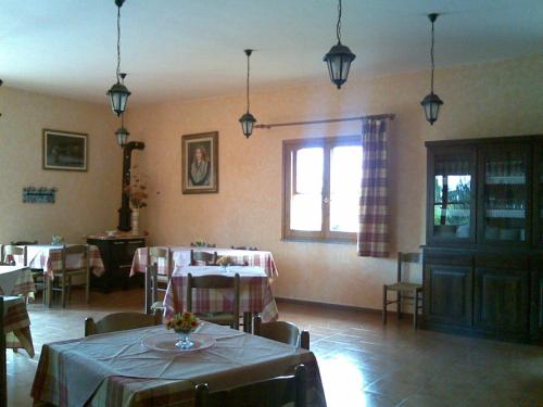 uma sala de jantar com duas mesas e uma janela em La Tavernetta em Masainas