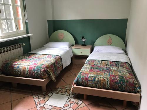 two beds in a room with green walls at L’ulivo in Ciriè