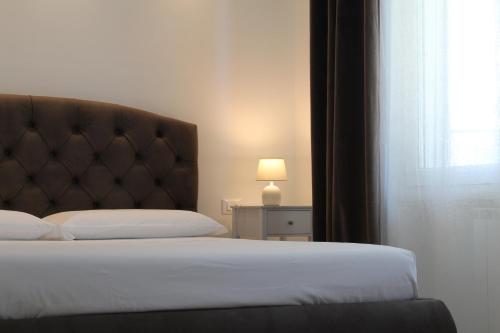 a bedroom with a bed with a headboard and a window at Villa Forte Salvi - Rooms in Peschiera del Garda