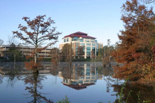 a building with its reflection in the water at Residence Inn by Marriott Monroe in Monroe