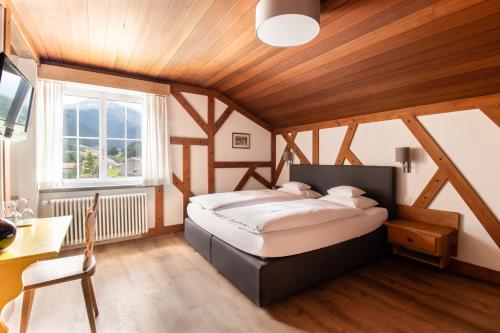 1 dormitorio con 1 cama en una habitación con techos de madera en Tgesa Romana en Savognin