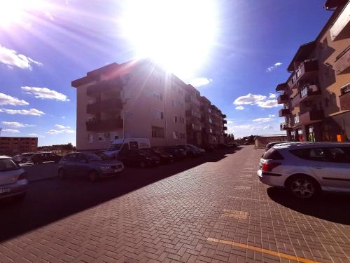 a street with cars parked in a parking lot at Gold Apartman in Subotica