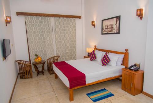 a bedroom with a bed and a telephone in it at Mahi Beach Hotel & Restaurant 