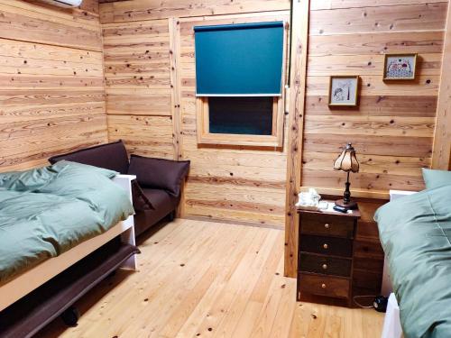 uma cabina de madeira com 2 camas e uma janela em Shimanologhouse - Vacation STAY 41662v em Iki