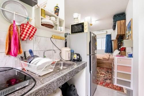 a kitchen with a sink and a refrigerator at Island Haven Phuket - Mai Khao in Ban Muang Mai (1)