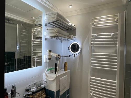 une salle de bain avec un lavabo, un miroir et des serviettes dans l'établissement Appartement Montmartre Sacré Cœur, à Paris