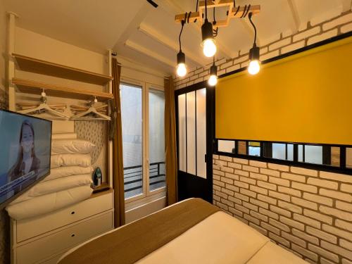 - une chambre avec un lit et un mur jaune dans l'établissement Appartement Montmartre Sacré Cœur, à Paris