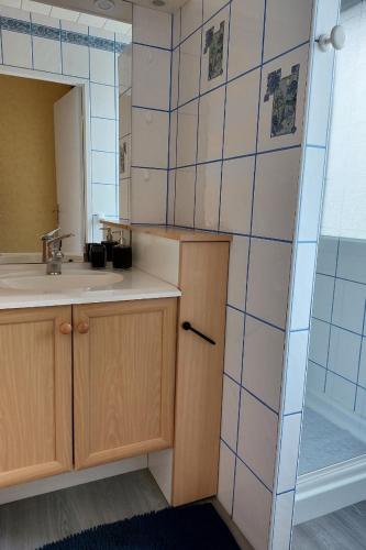 une salle de bain avec un lavabo et un miroir dans l'établissement Maison Mitoyenne entre les lacs, proche du centre ville de Gérardmer, à Gérardmer