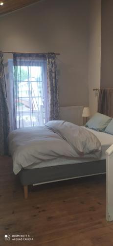 a bed sitting in a bedroom with a window at logement indépendant attenant à une maison dans grand jardin in Retournac