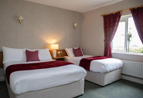 a hotel room with two beds and a window at Sliabh Beagh Hotel in Monaghan