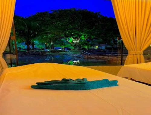 a pair of gloves sitting on top of a bed at Carpe Diem Eco Resort Olímpia in Olímpia