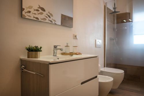 uma casa de banho com um lavatório e um WC em Perla Marina Appartamento em Rimini