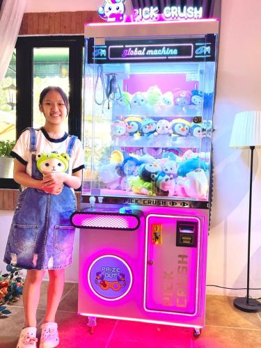 a young girl standing next to a pink vending machine at De Vivre Homestay Măng Đen in Kon Von Kla