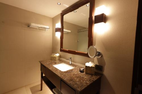 a bathroom with a sink and a mirror at Taj Wayanad Resort & Spa, Kerala in Wayanad