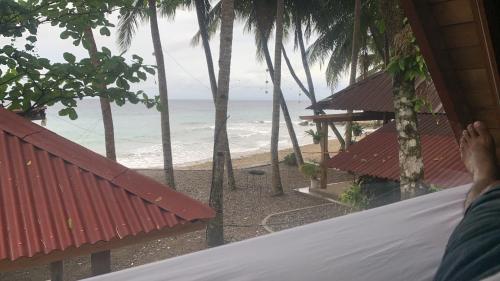 a person laying on a bed looking at the beach at A-House Beachfront in Bootin