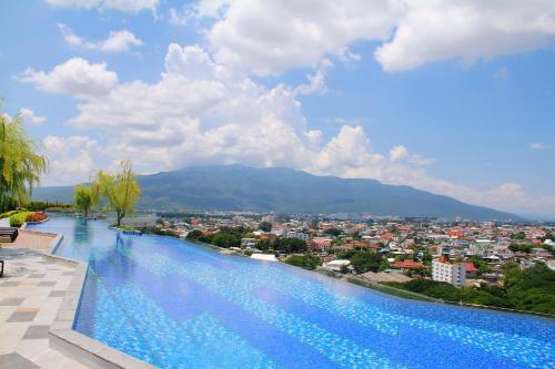 a large swimming pool with a view of a city at The Astra Sky River in Chiang Mai