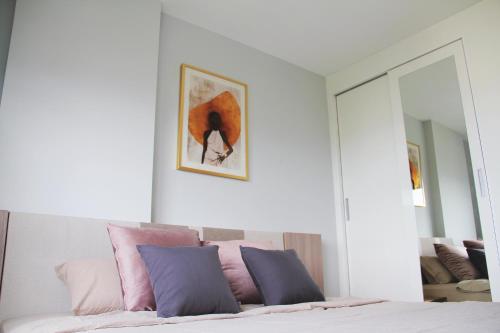 a bedroom with a bed with pink and blue pillows at The Astra Sky River in Chiang Mai