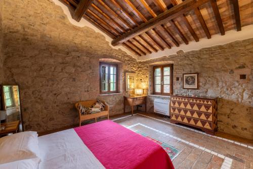 ein Schlafzimmer mit einem großen Bett in einem Steingebäude in der Unterkunft Podere Ostoncino in Chianni