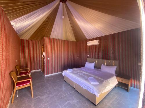 a bedroom with a bed and a chair in a tent at Wadi Rum Santa Camp in Wadi Rum