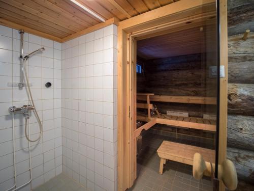 a bathroom with a shower and a bench in it at Fell Centre Kiilopää, Hotelli Niilanpää in Saariselka