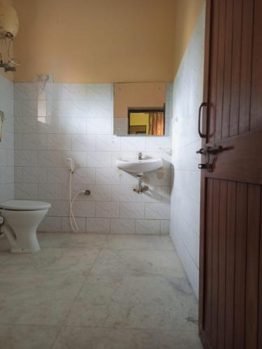 a bathroom with a toilet and a sink at MADHUR RESIDENCY in Puri