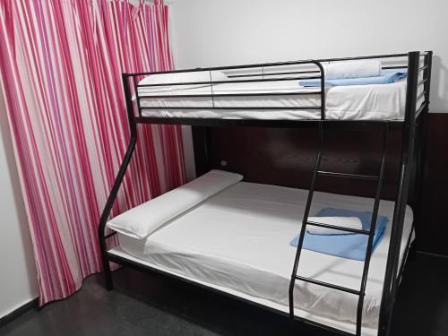 a room with two bunk beds and a curtain at Apartamentos Turísticos Los Ángeles in Alcazar de San Juan