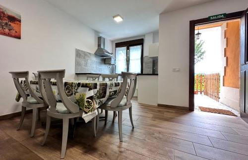 a kitchen and dining room with a table and chairs at Apartamentos Rurales Sobremazas in Sobremazas