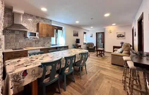 Apartamentos Rurales Sobremazas في Sobremazas: مطبخ وغرفة معيشة مع طاولة وكراسي كبيرة