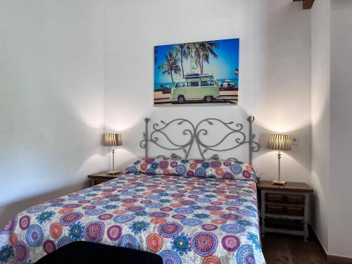a bedroom with a bed and two lamps and a painting at Apartamentos Rurales Sobremazas in Sobremazas