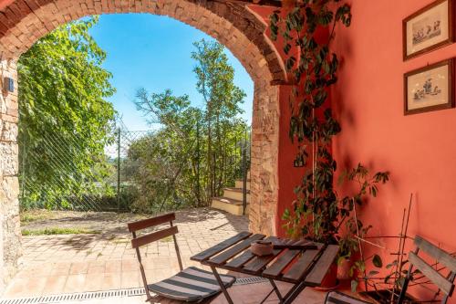 an archway in a building with a table and a chair at La Casina nel Borgo in Murlo