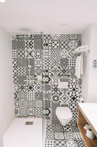 a bathroom with a black and white tiled wall at Utopia Hotel - Art & Nature Hotel in Mons