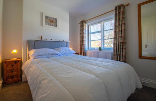a bedroom with a large bed and a window at Flint Cottage - 2 Bedrooms - Rye Town Centre in Rye