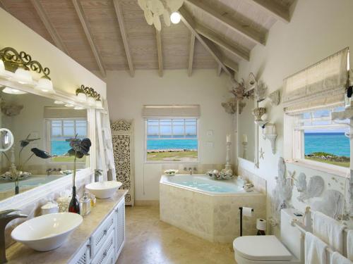 a large bathroom with two sinks and a tub at Larimar - Luxury Ocean Front Villa in Saint Philip